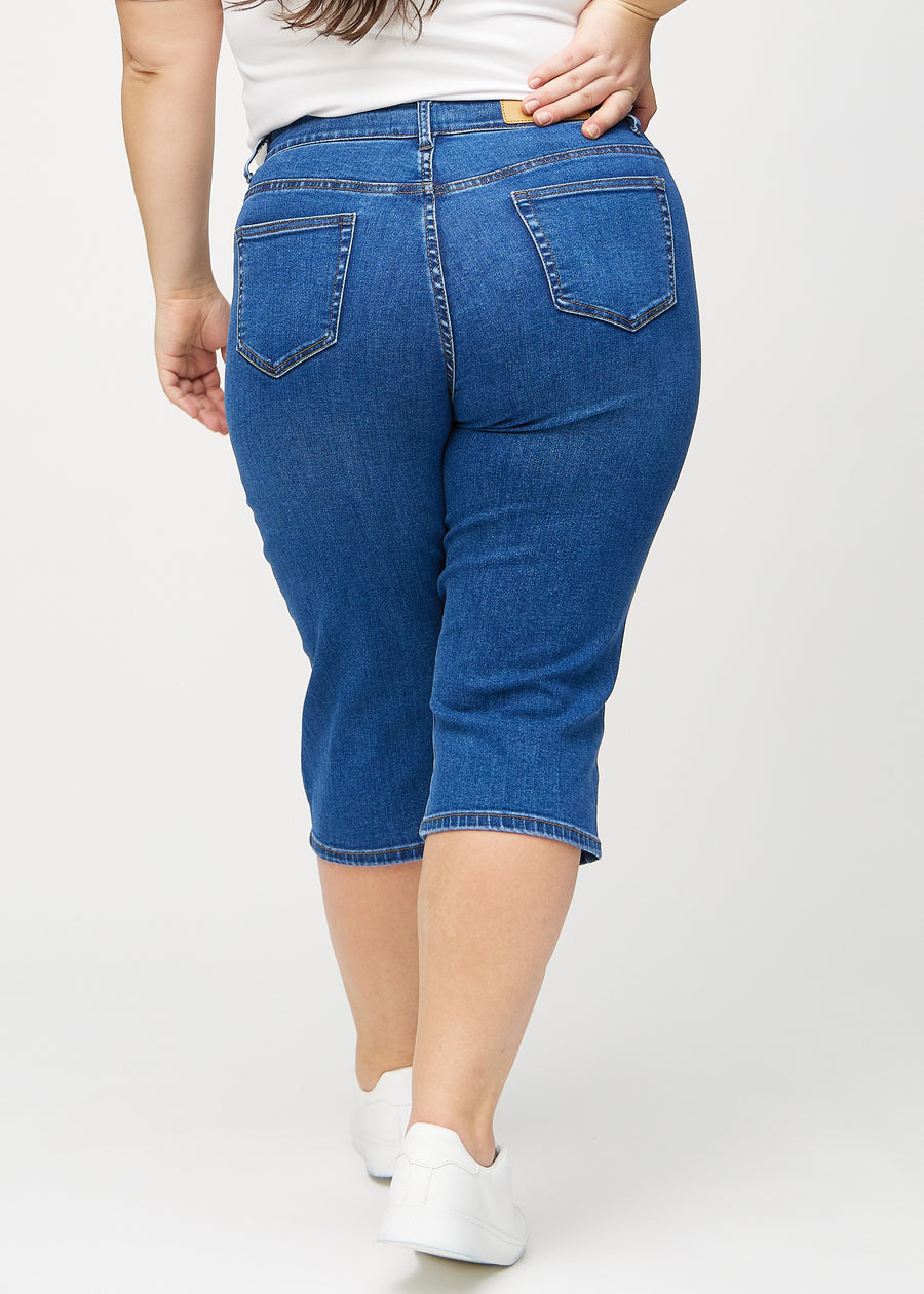 Mörk denim regular capris sett bakifrån på en plus size-modell, så att man kan se hela produkten.