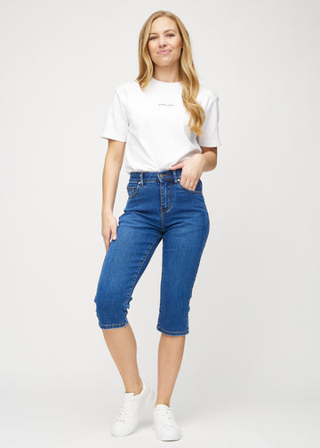 Helbild av modell i mörk denim regular capris.