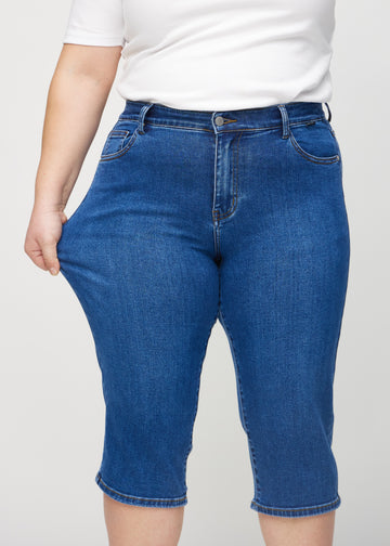 Plus size-modellen sträcker caprisen vid låret för att visa stretch.