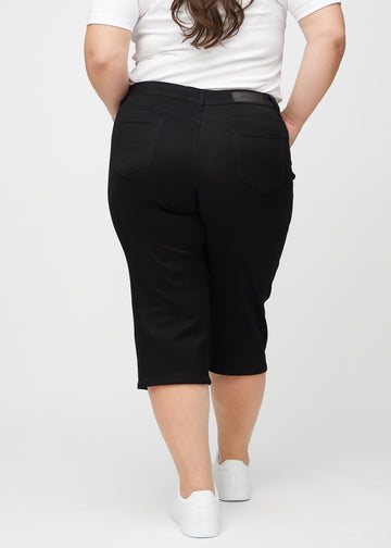 Svarta regular capris sett bakifrån på en plus-size-modell, så att man kan se hela produkten.