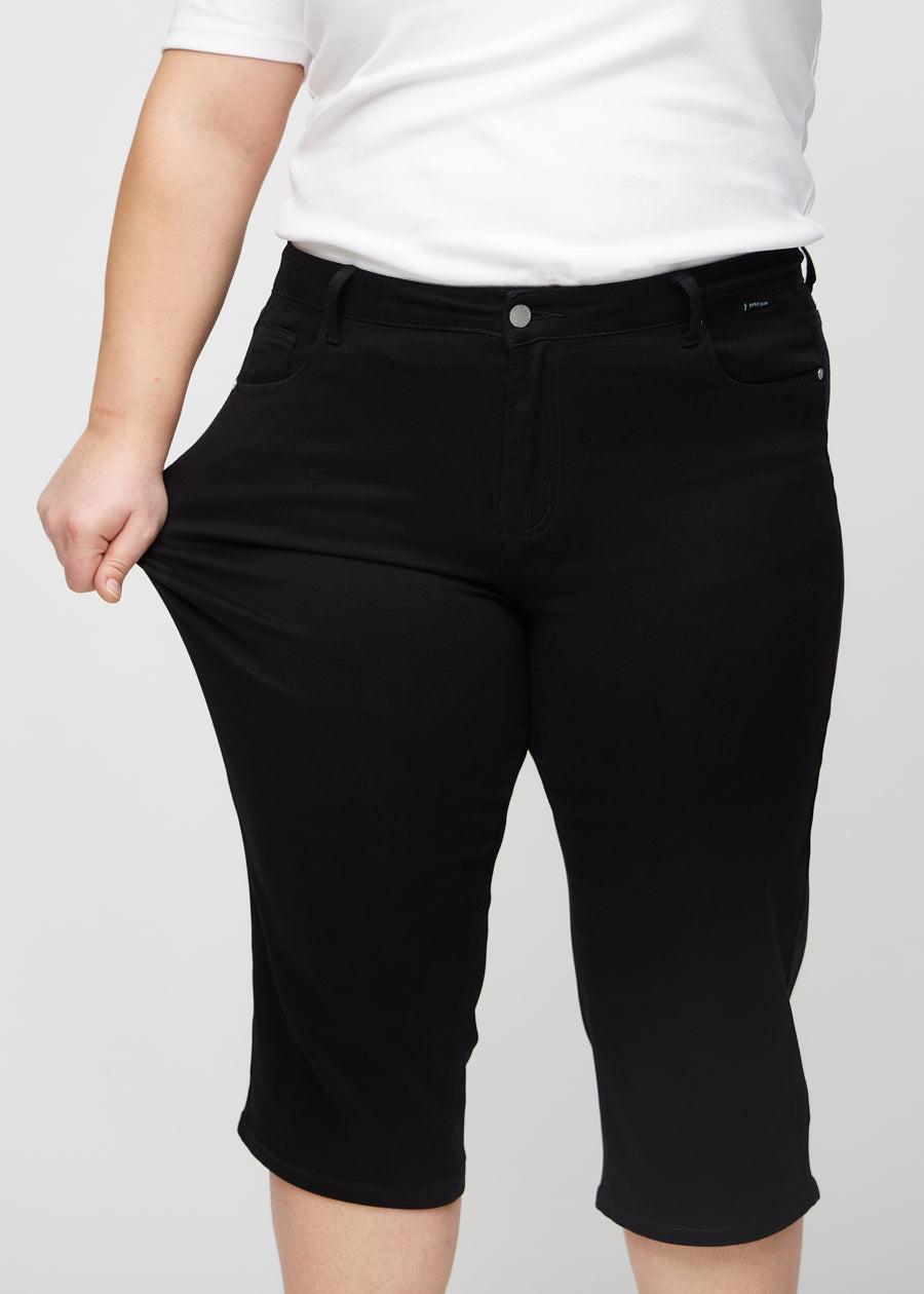 Plus-size-modellen drar ut caprisen vid låret för att visa stretch.