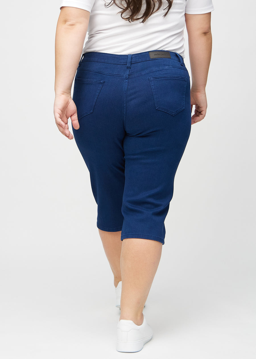 Mörkblå regular capris sedda bakifrån på en plus size-modell, så att man kan se hela produkten.
