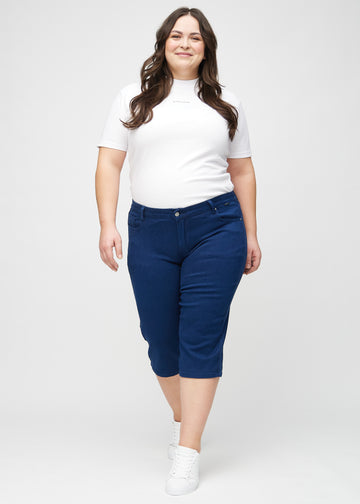 Helbild av en plus size-modell i mörkblå regular capris.