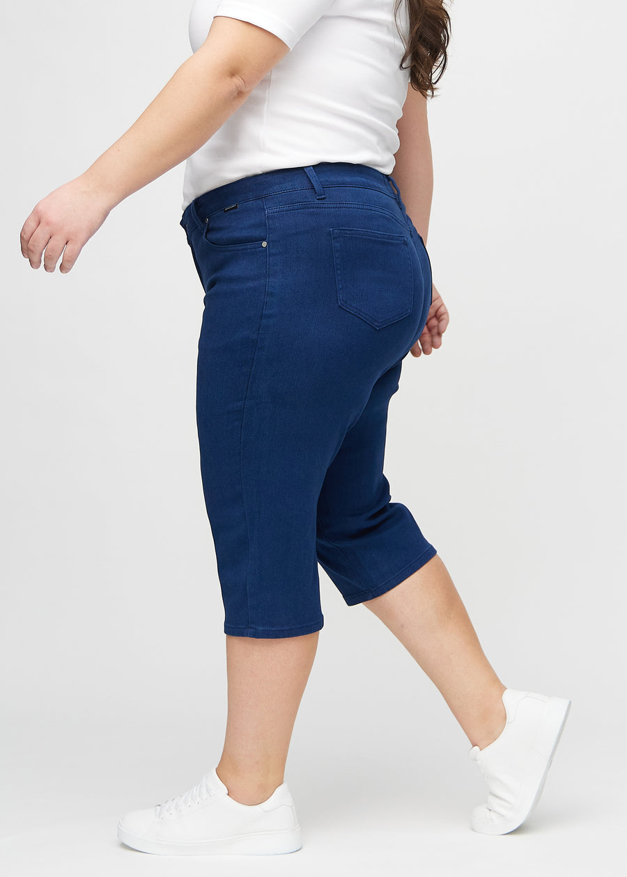 Mörkblå regular capris sedda från sidan på en plus size-modell.