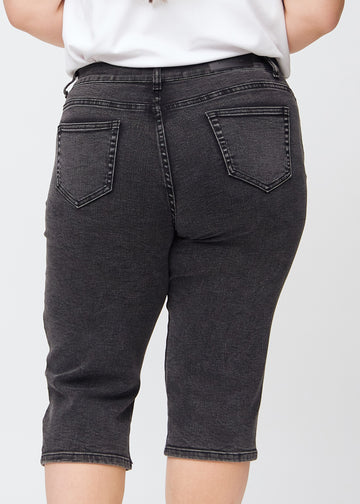 Mörkgrå denim regular capris sedd bakifrån i närbild på en plus-size-modell för att visa detaljer.