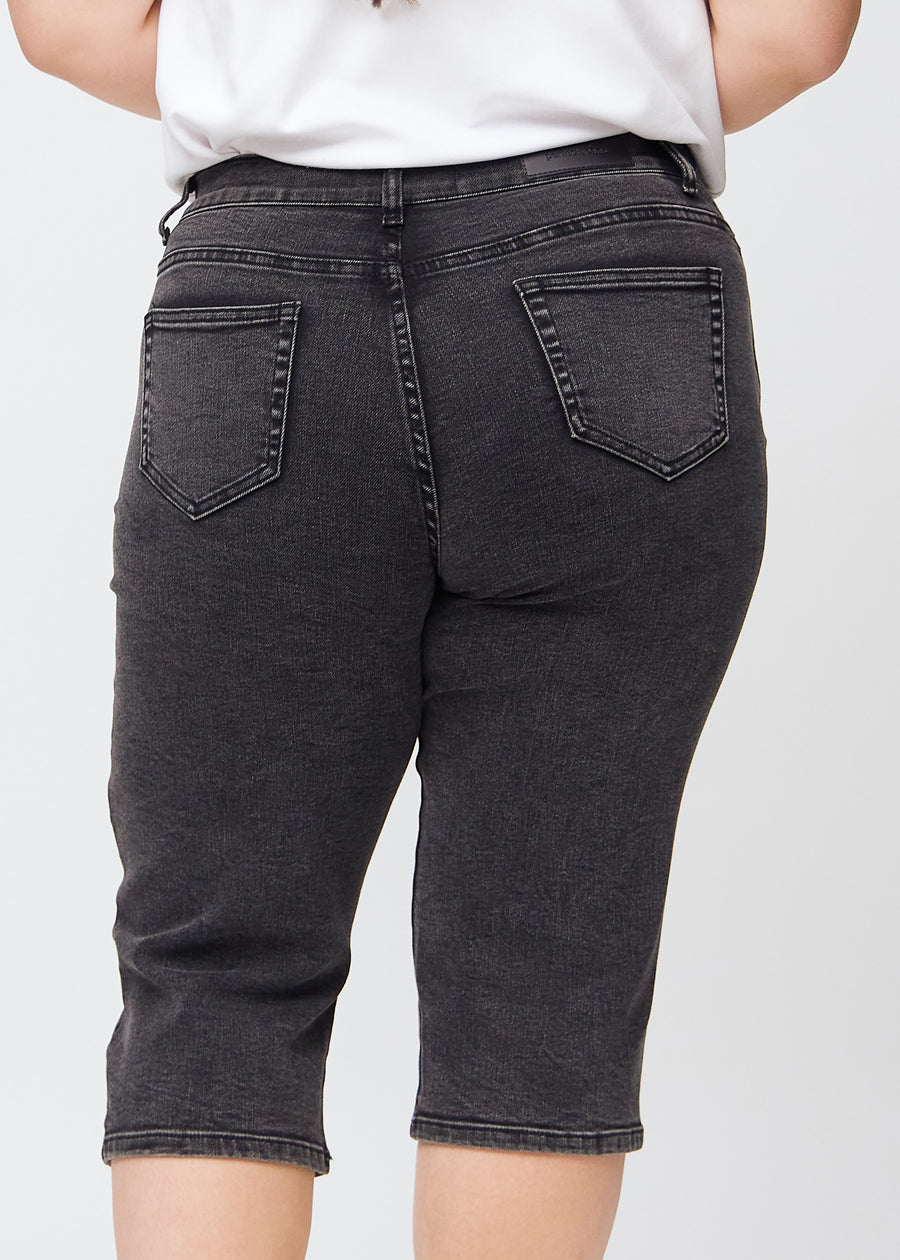 Mörkgrå denim regular capris sedd bakifrån i närbild på en plus-size-modell för att visa detaljer.