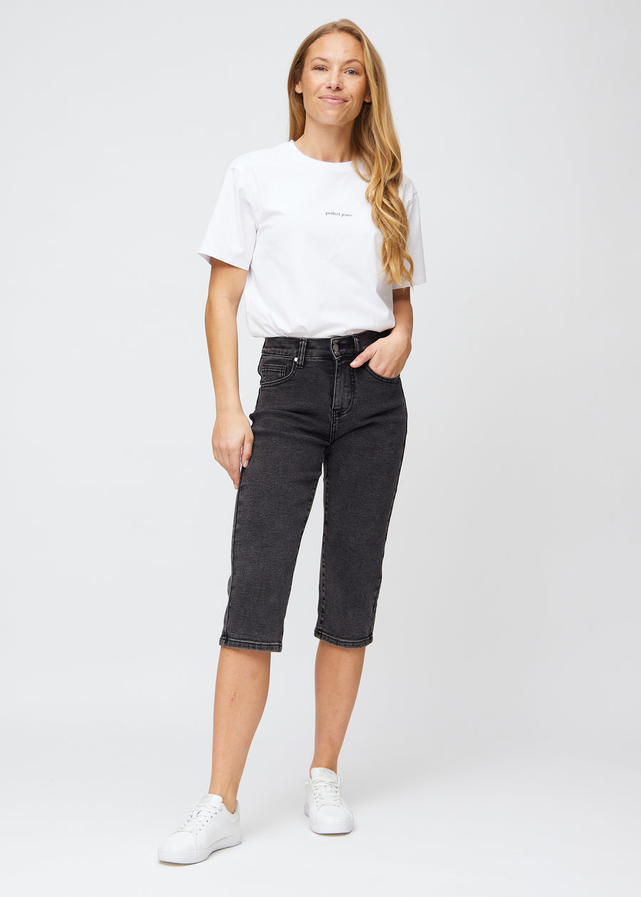 Helbild av modell i mörkgrå denim regular capris.