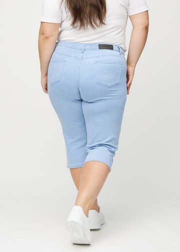 Ljusblå regular capris sedda bakifrån på en plus size-modell, så att man kan se hela produkten.