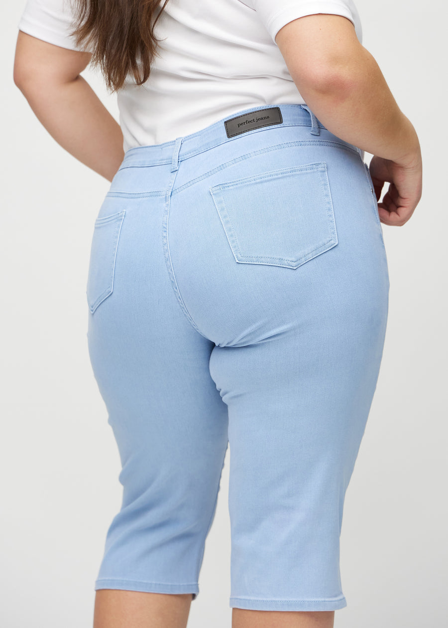 Ljusblå regular capris sedda bakifrån i närbild på en plus size-modell för att visa detaljer.