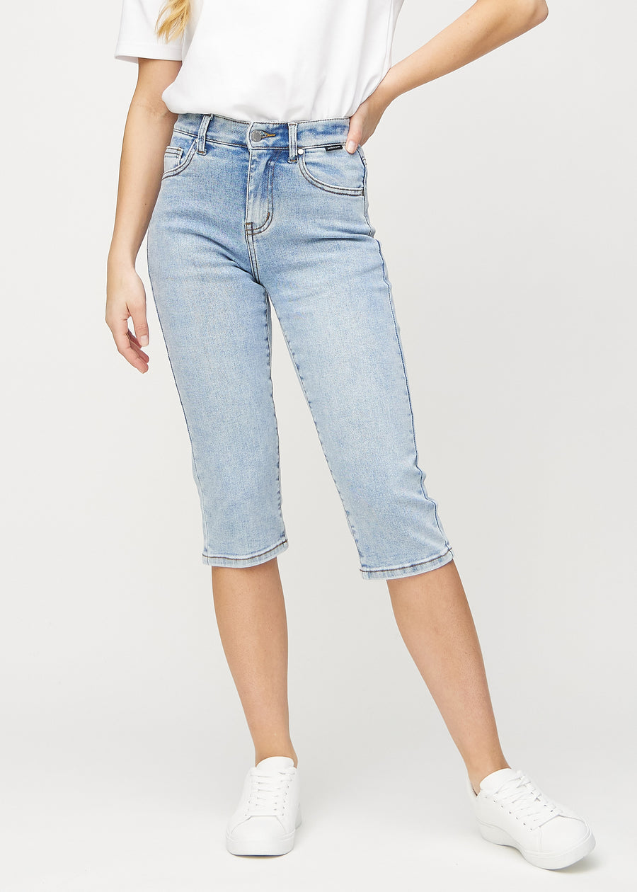 Ljus denim regular capris, modellnamn Waves, som sitter rakt längs benet och slutar precis under knät, sedd framifrån.