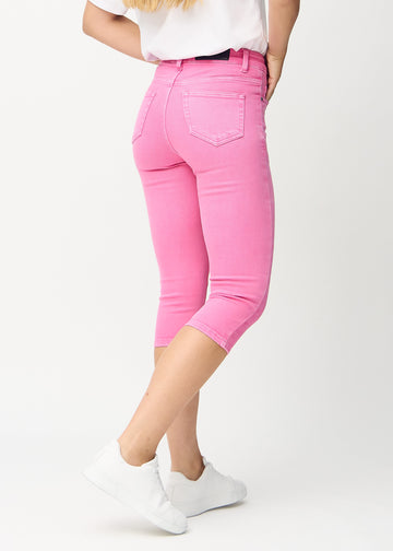 Skinnycapris för kvinnor i pastellrosa jeanstyg, färgen Flamingos. Bakifrån på en modell, med fokus på passform och bakfickor.