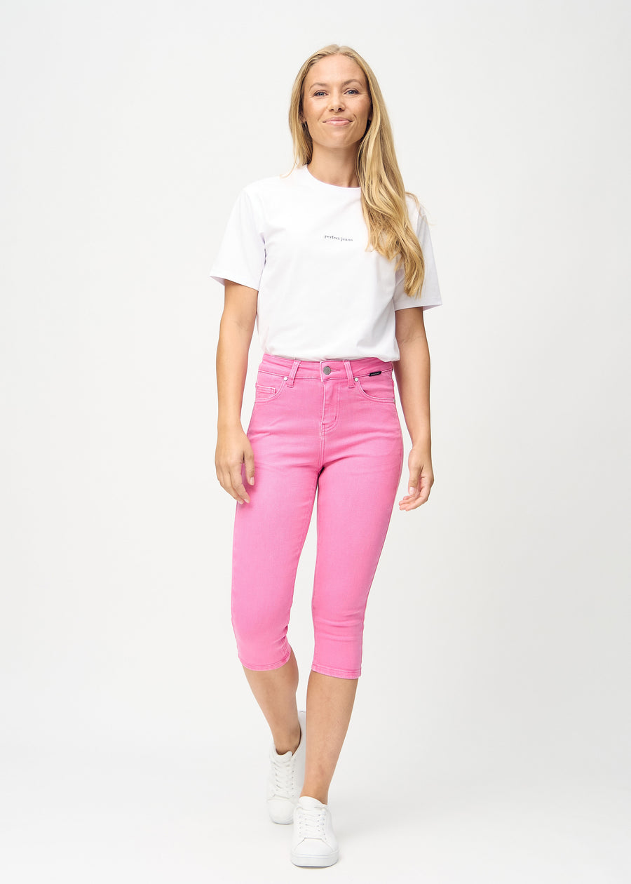 Skinnycapris för kvinnor i pastellrosa jeanstyg, färgen Flamingos. Helbild av en modell som bär capris.