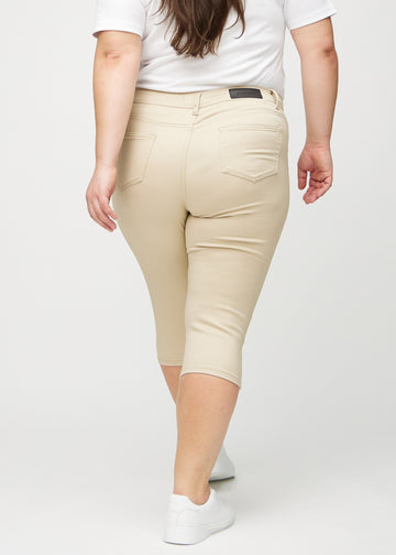 Skinnycapris för kvinnor i beige jeanstyg, färgen Gazelles. Bakifrån på en plus size-modell, med fokus på passform och bakfickor.