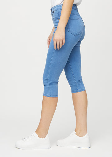 Skinnycapris för kvinnor i blått jeanstyg, färgen Geraniums. Från sidan på en modell, med åtsittande passform.