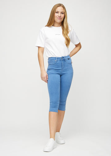 Skinnycapris för kvinnor i blått jeanstyg, färgen Geraniums. Helbild av en modell som bär capris.