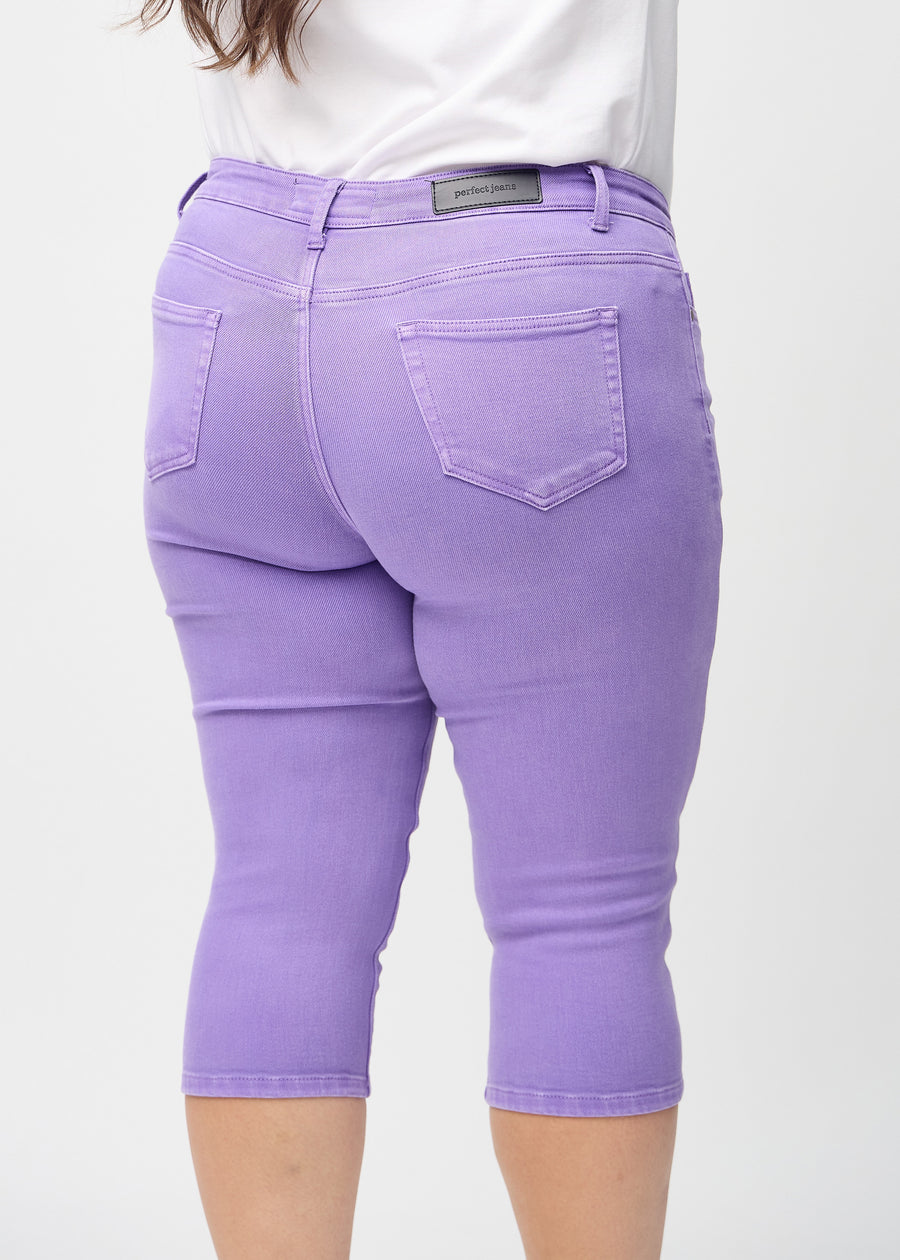 Skinnycapris för kvinnor i pastellila jeanstyg, färgen Lavenders. Närbild bakifrån på en plus size-modell, med fokus på fickor och sömmar.