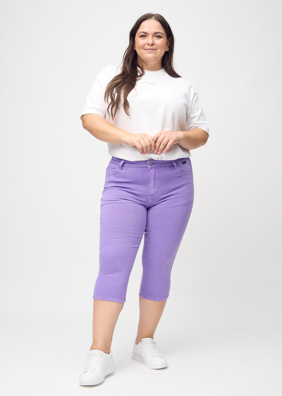 Skinnycapris för kvinnor i pastellila jeanstyg, färgen Lavenders. Helbild av en plus size-modell som bär capris.
