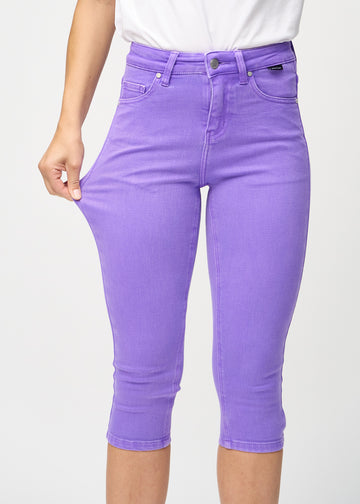 Skinnycapris för kvinnor i pastellila jeanstyg, färgen Lavenders. En modell drar i tyget för att visa flexibiliteten.