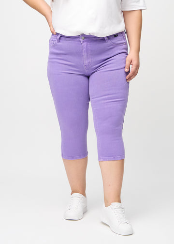 Skinnycapris för kvinnor i pastellila jeanstyg, färgen Lavenders. Framifrån på en plus size-modell, med åtsittande ben till strax under knät.