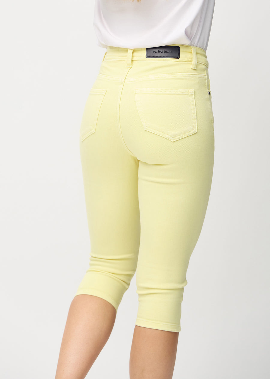 Närbild bakifrån av ljusgula Skinny-capribyxor i färgen Lemonades, med fokus på bakfickor och sömmar.