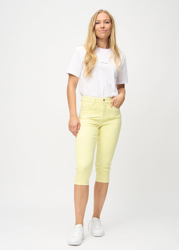 Helkroppsbild av en modell i ljusgula Skinny-capribyxor i färgen Lemonades.