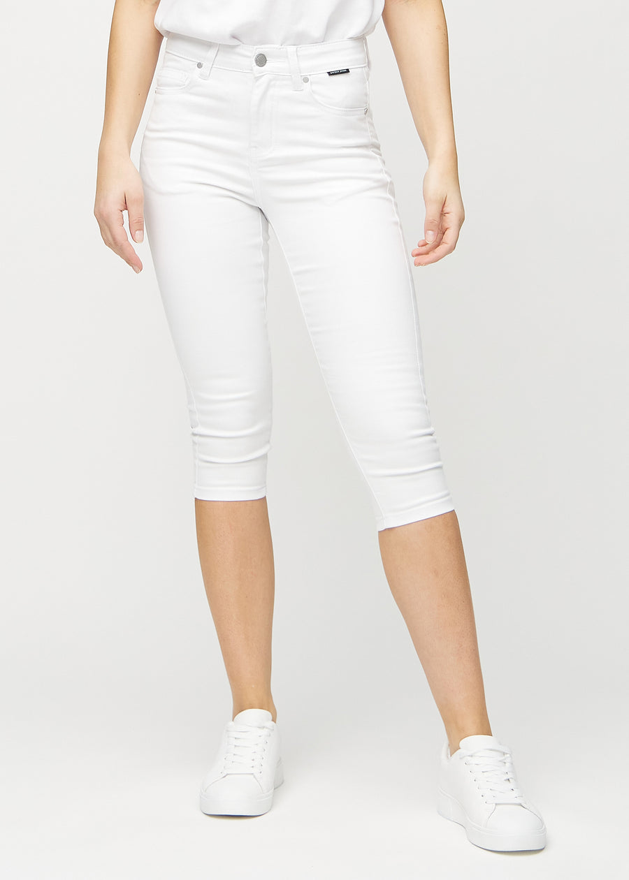 Skinnycapris för kvinnor i vitt jeanstyg, färgen Marguerites. Framifrån på en modell, med åtsittande ben till strax under knät.