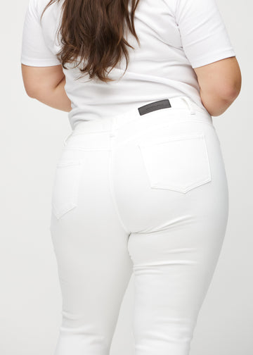 Skinnycapris för kvinnor i vitt jeanstyg, färgen Marguerites. Närbild bakifrån på en plus size-modell, med fokus på fickor och sömmar.