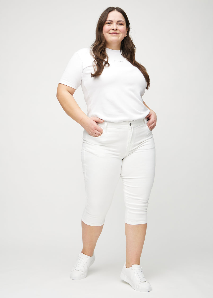 Skinnycapris för kvinnor i vitt jeanstyg, färgen Marguerites. Helbild av en plus size-modell som bär capris.