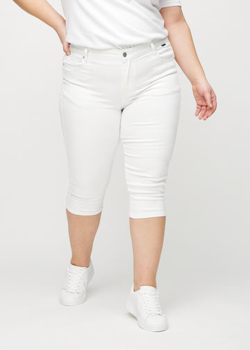 Skinnycapris för kvinnor i vitt jeanstyg, färgen Marguerites. Framifrån på en plus size-modell, med åtsittande ben till strax under knät.