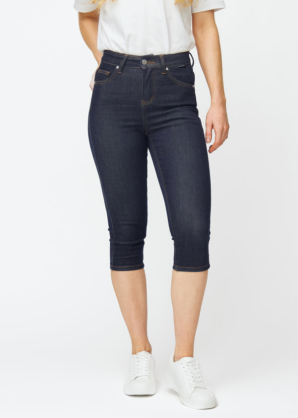 Mörkblå denim capris för dam i färgen Midnights med skinny passform som sitter tätt från höften till under knät, sett framifrån.