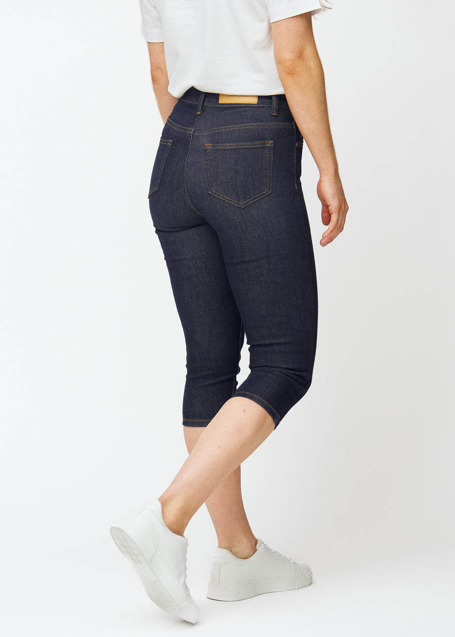 Mörkblå denim capris för dam i färgen Midnights sett bakifrån, där längden under knät syns.
