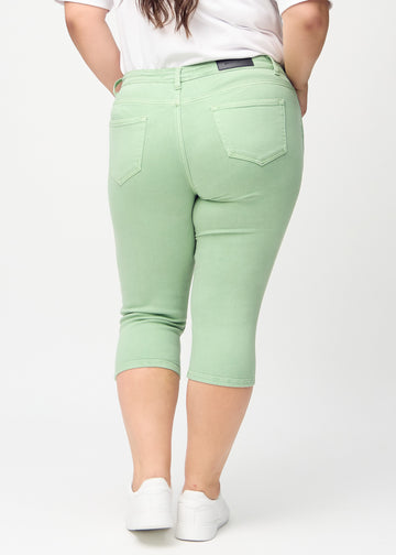 Skinnycapris för kvinnor i pastellgrönt jeanstyg, färgen Mints. Bakifrån på en plus size-modell, med fokus på passform och bakfickor.