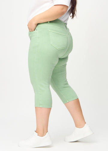 Skinnycapris för kvinnor i pastellgrönt jeanstyg, färgen Mints. Från sidan på en plus size-modell, med åtsittande passform.