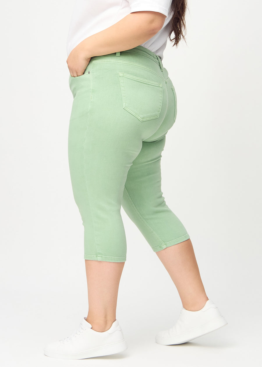 Skinnycapris för kvinnor i pastellgrönt jeanstyg, färgen Mints. Från sidan på en plus size-modell, med åtsittande passform.