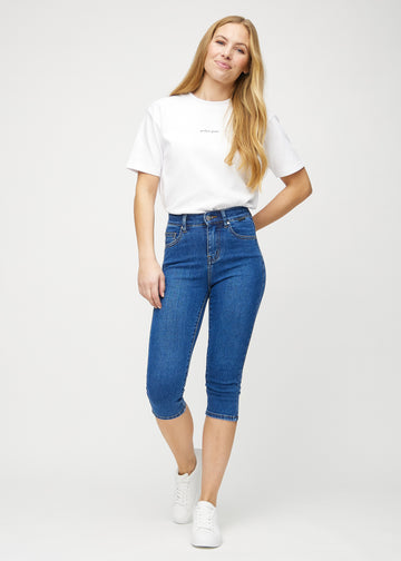 Skinnycapris för kvinnor i mörkblå denim, färgen Oceans. Helbild av en modell som bär capris.