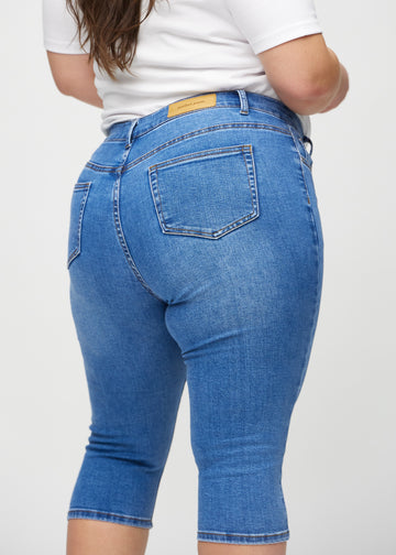 Denim skinny capris sedd bakifrån i närbild på en plus size-modell för att visa detaljer.