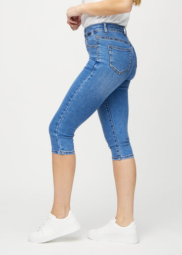 Denim skinny capris sedd från sidan på modell.