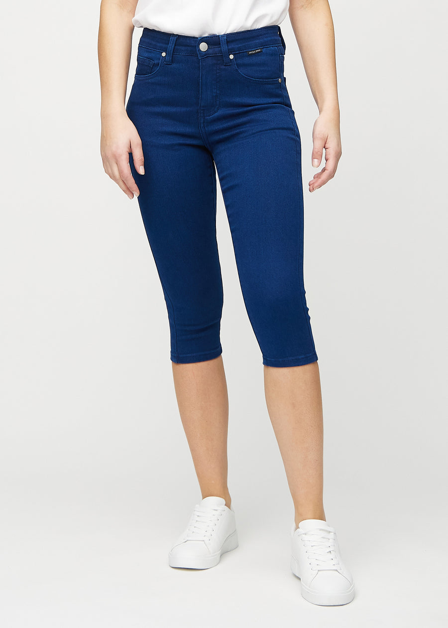 Skinnycapris för kvinnor i mörkblått jeanstyg, färgen Royals. Framifrån på en modell, med åtsittande ben till strax under knät.