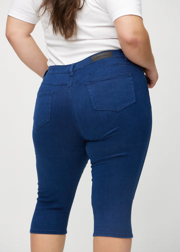 Skinnycapris för kvinnor i mörkblått jeanstyg, färgen Royals. Närbild bakifrån på en plus size-modell, med fokus på fickor och sömmar.