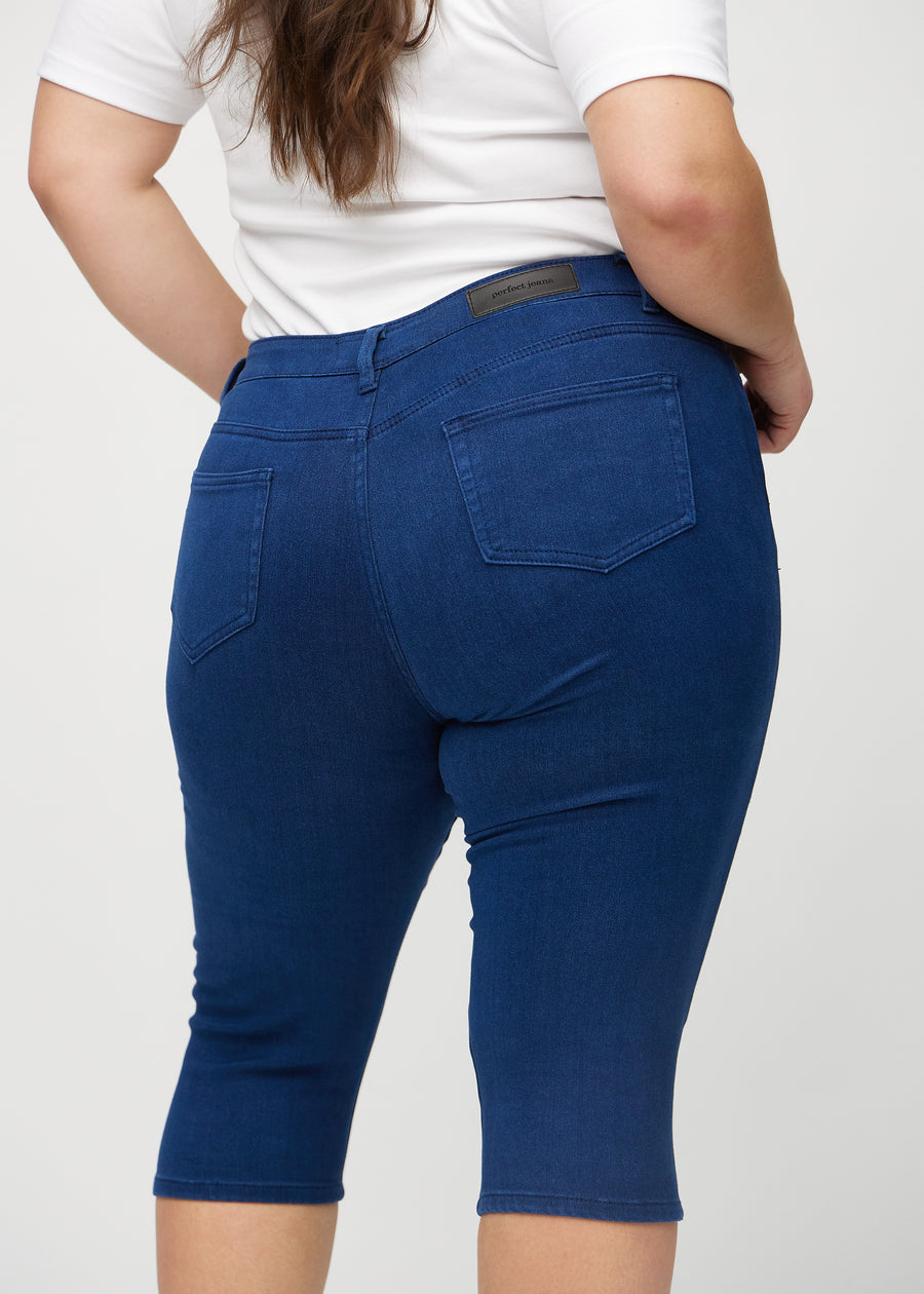 Skinnycapris för kvinnor i mörkblått jeanstyg, färgen Royals. Närbild bakifrån på en plus size-modell, med fokus på fickor och sömmar.