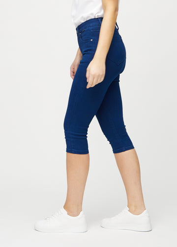 Skinnycapris för kvinnor i mörkblått jeanstyg, färgen Royals. Från sidan på en modell, med åtsittande passform.