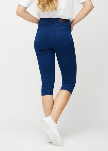 Skinnycapris för kvinnor i mörkblått jeanstyg, färgen Royals. Bakifrån på en modell, med fokus på passform och bakfickor.
