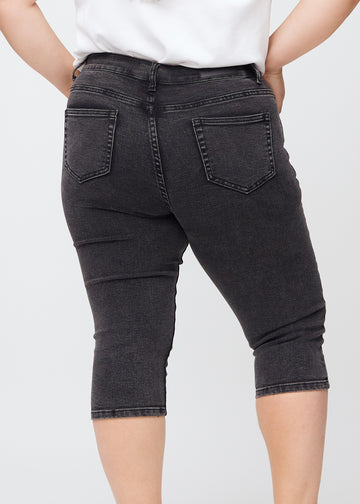 Skinnycapris för kvinnor i mörkgrå denim, färgen Shadows. Närbild bakifrån på en plus size-modell, med fokus på fickor och sömmar.
