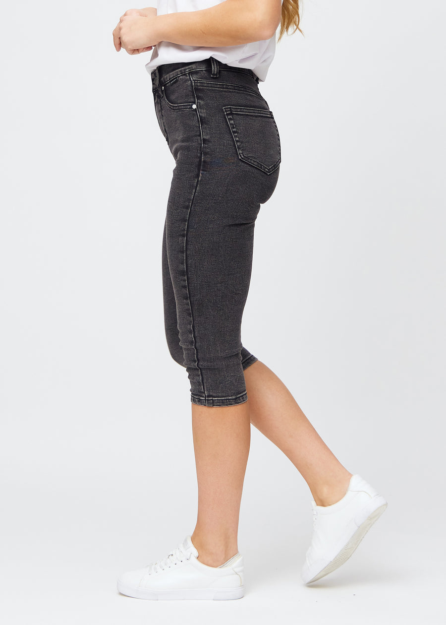 Kvinna i mörkgrå Shadows denimcapris i skinny fit, sedd från sidan.