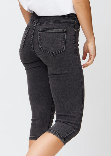 Skinnycapris för kvinnor i mörkgrå denim, färgen Shadows. Närbild bakifrån på en modell, med fokus på fickor och sömmar.