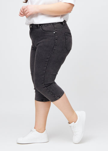 Skinnycapris för kvinnor i mörkgrå denim, färgen Shadows. Från sidan på en plus size-modell, med åtsittande passform.