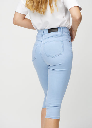 Ljusblå skinny capris sett bakifrån på nära håll för att visa detaljer.