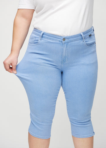 Plus-size-modellen sträcker caprisen vid låret för att visa stretchen.