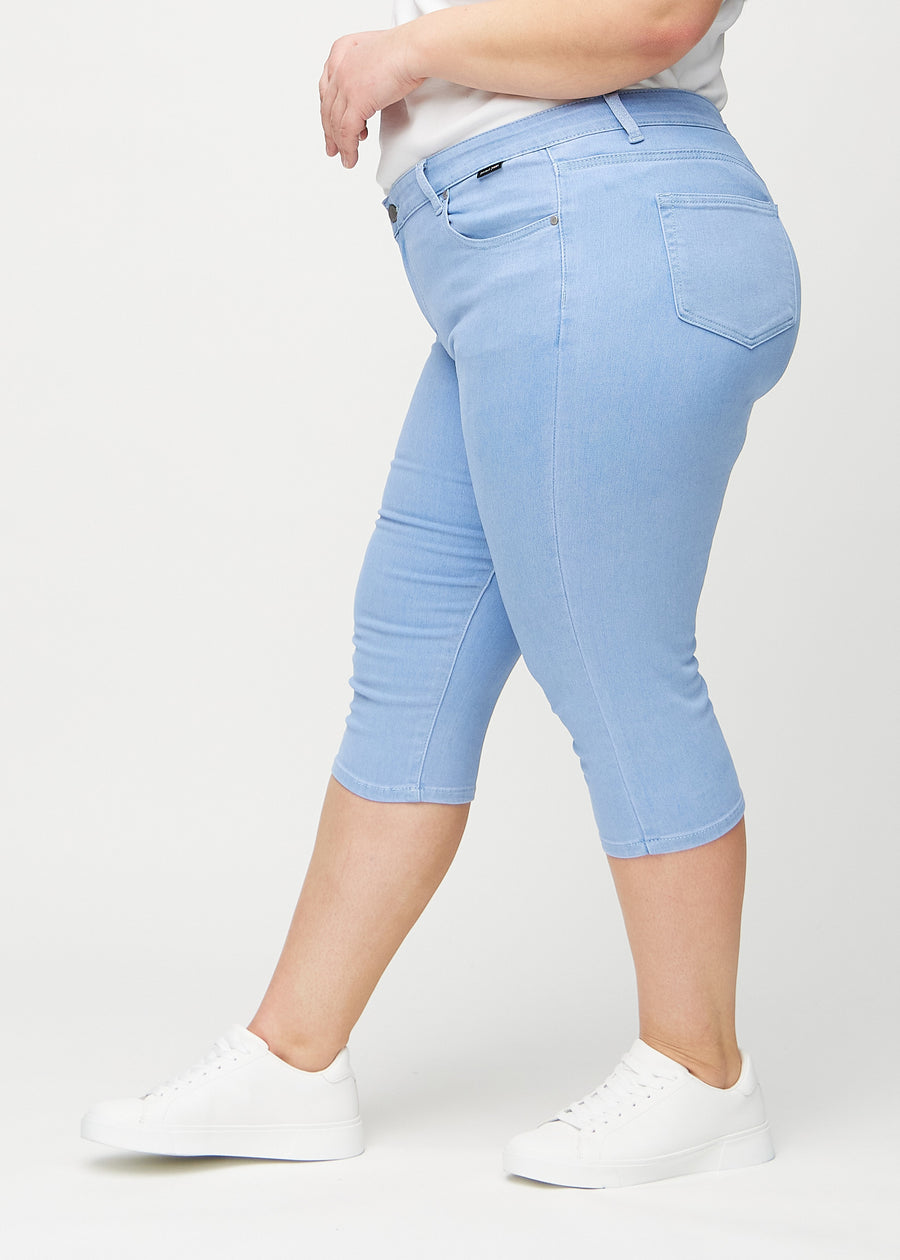 Ljusblå skinny capris sett från sidan på en plus-size-modell.