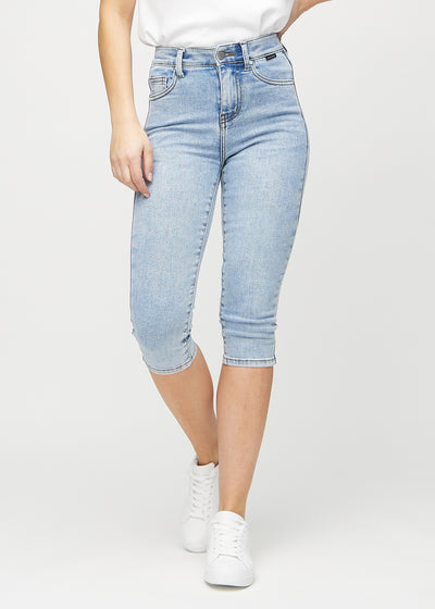 Skinnycapris för kvinnor i ljusblå denim, färgen Waves. Framifrån på en modell, med åtsittande ben till strax under knät.